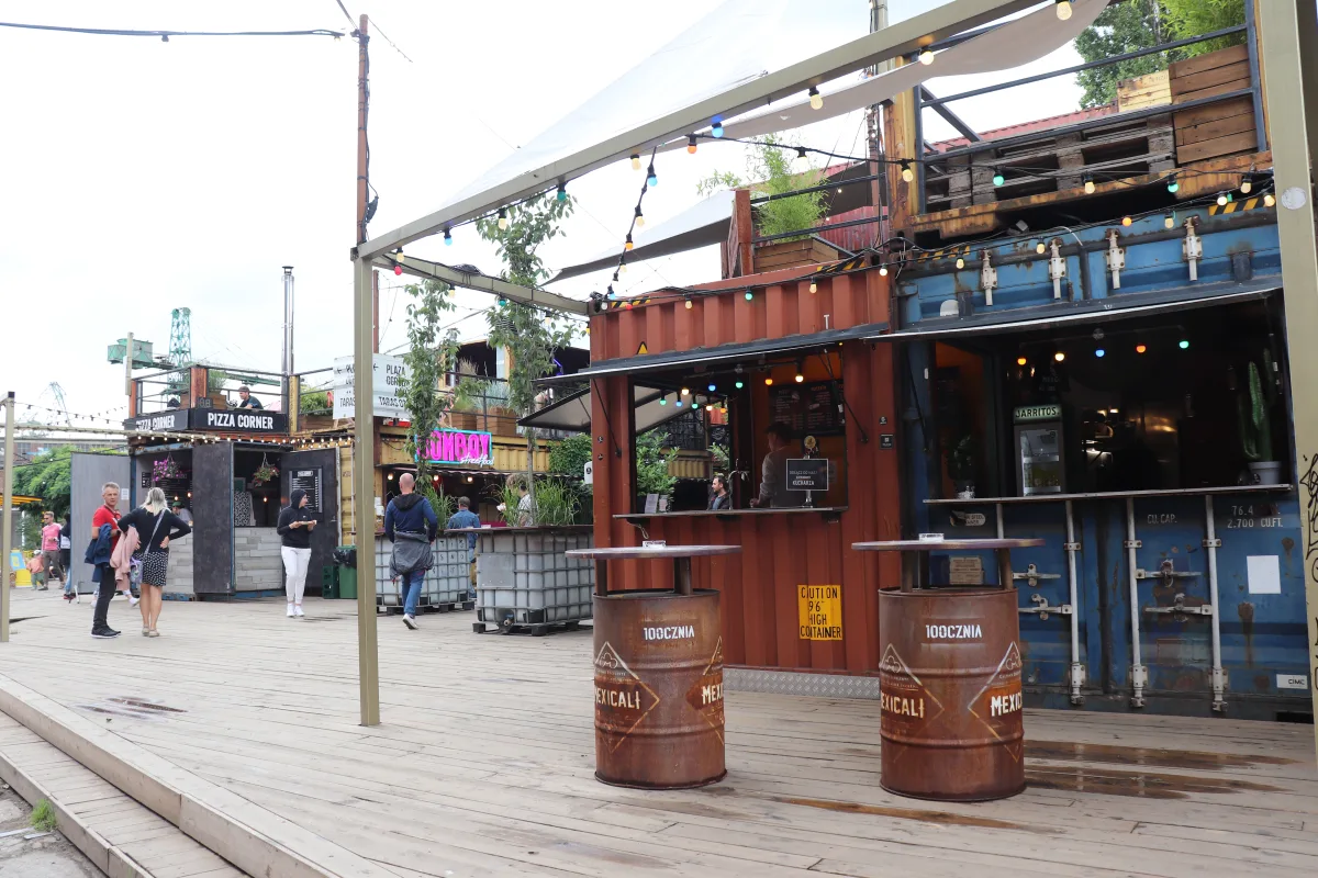 Container-Bauten der 100cznia im Danziger Werftgelände — bunte Fassaden mit Streetfood-Ständen und Sitzgelegenheiten