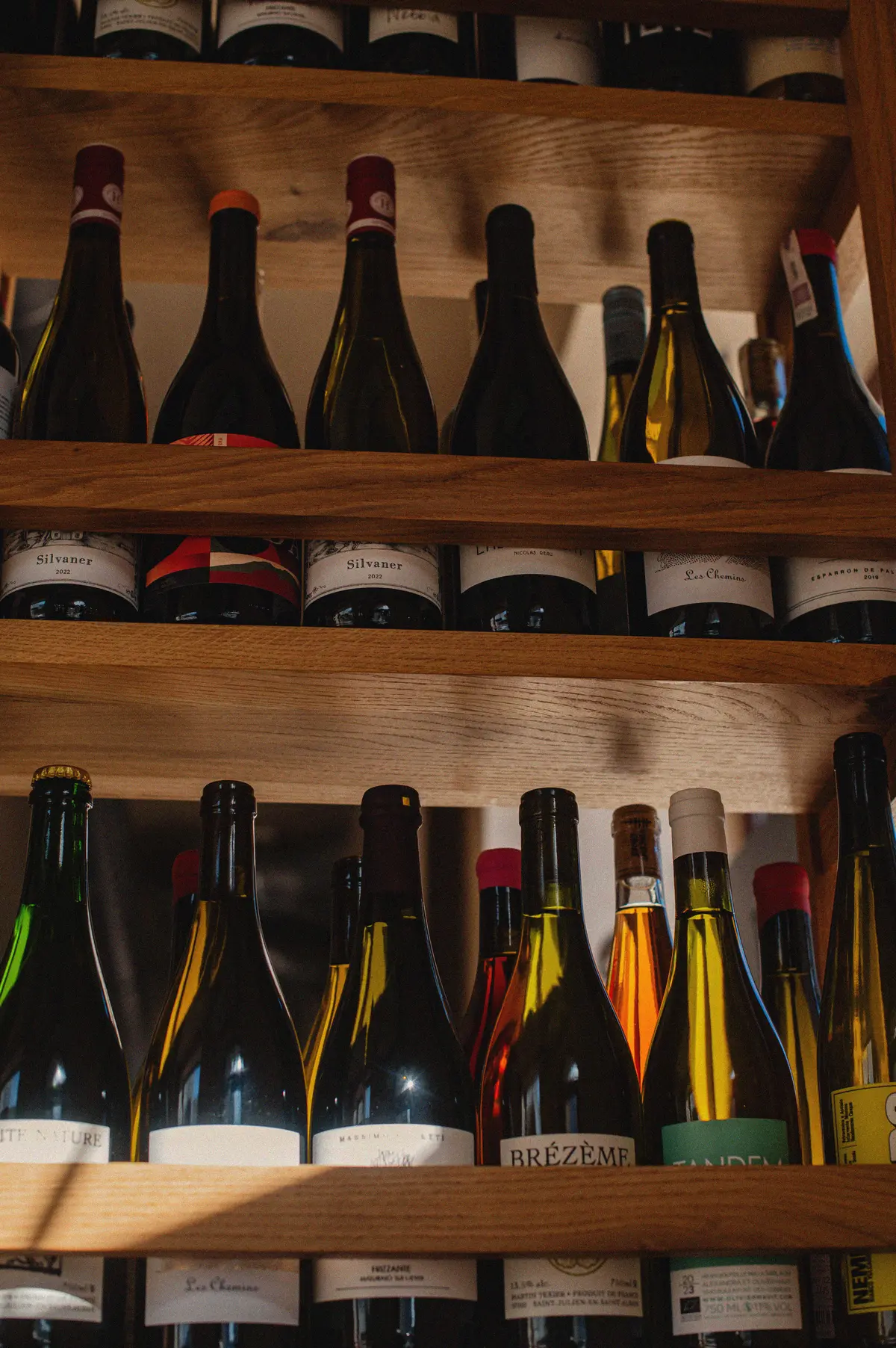 Naturwein-Flaschen auf Holzregalen im Brut Bistro — die kuratierte Auswahl von Sommelier Maciej Łyko