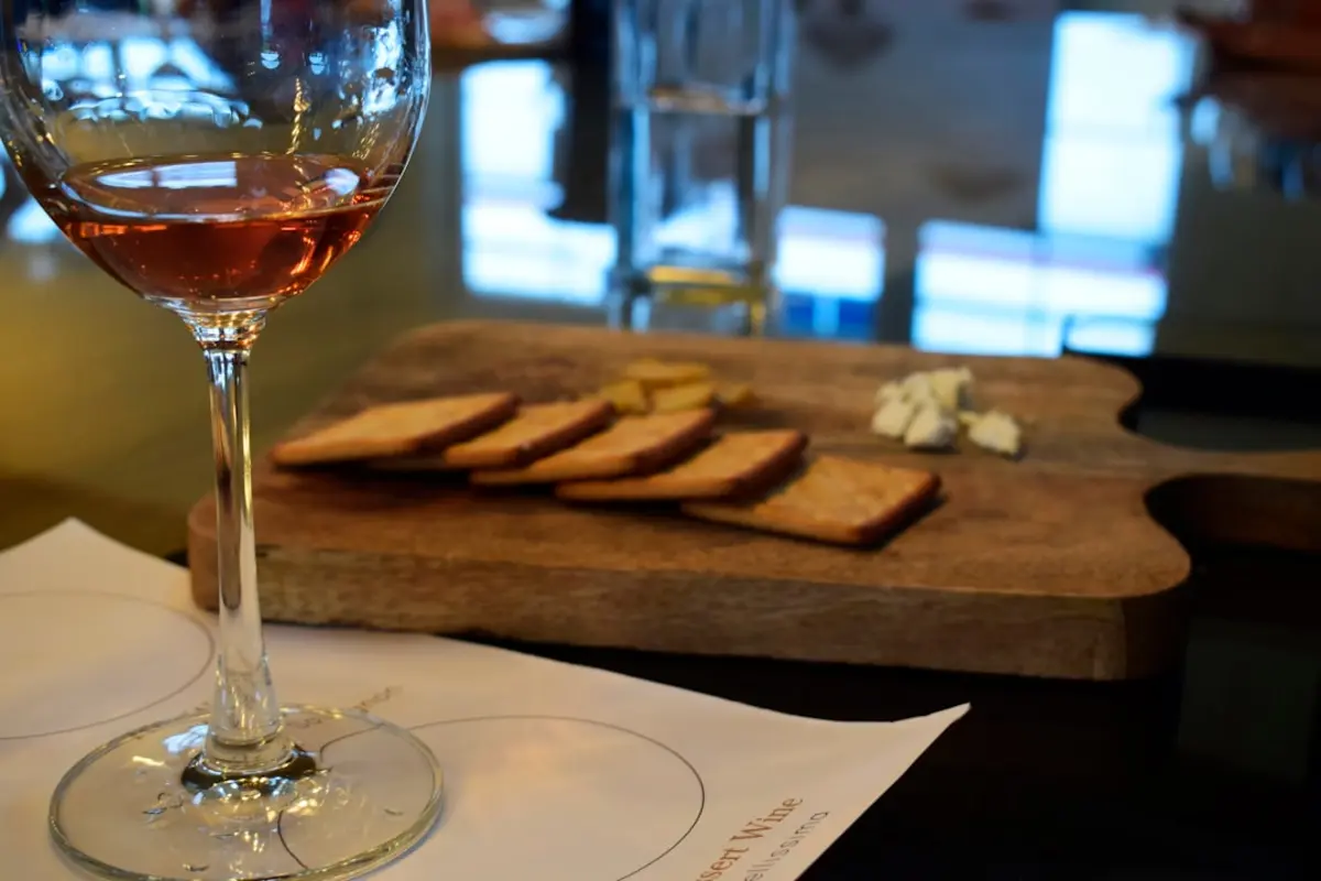 Weinglas und Käseplatte auf einem Holztisch — Wein und Essen als Einheit in einer Weinbar